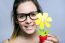 Beautiful Young Woman Showing One Artificial Daisy