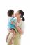 Asian Mother Carrying And Soothe Her Daughter On White Background