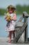 Little Girl With Flowers On A Bridge