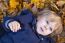 Small Blond Boy With Blue Eyes Lays On Bed Of Autumn Fallen Leav