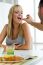 Happy Young Couple Enjoying Breakfast In The Kitchen