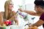 Happy Young Couple Enjoying Breakfast In The Kitchen