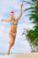 Young Blonde Woman In Bikini And Christmas Santa Hat Jumping On