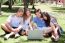 Friends Enjoying Movie In Park On Laptop