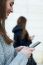 Two Young Businesswoman Using Mobile Phone In The Street