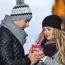 Young Couple In Love Embracing And Drinking Hot Drink From Red C