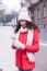 Beautiful Woman In Red Coat And Wool Cap And Gloves With Smartph