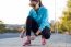 Female Athlete Tying Laces For Jogging