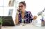 Pretty Young Woman Using Her Mobile Phone In The Office