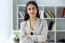 Pretty Young Businesswoman Looking At Camera In The Office