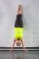 Middle Age Woman Doing Handstand Across Wall