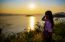 Happy Young Woman Standing Watching The Sunset Over The Lake