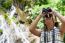 Girl Using Binoculars In Forest