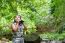 Girl Using Binoculars In Forest