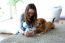 Beautiful Young Woman With Her Dog Using Mobile Phone At Home