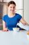 Woman Pouring Milk Into Cereal