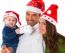 Happy Parents With Baby Boy Wearing Santa Hats