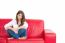 Beautiful Young Woman Sitting On Red Sofa