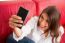 Young Woman Making Face While Taking Selfie On Sofa