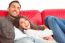 Cheerful Young Couple Relaxing On Sofa