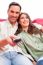 Happy Young Couple Watching Tv On Sofa