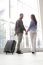 Portrait Of Happy Couple With Luggage At Airport