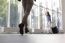 Woman With Luggage Waving To Boyfriend At Airport