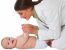 Happy Female Pediatrician Playing With Toddler