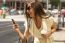 Fashionable Young Brunette Laughs Into Phone, Urban Background