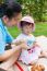 Vacation, Mother And Little Asian Girl Enjoy Eating Their Lunch