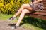 Young Woman Sitting On A Park Bench