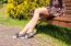 Young Woman Sitting On A Park Bench