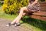 Young Woman Sitting On A Park Bench