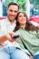 Happy Young Couple Watching Tv On Sofa