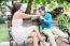 Loving Young Couple Flirting While Sitting At A Park Bench