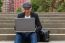 Student Working On His Laptop With An Irish Cap