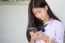 Portrait Of Thai Student Teen Beautiful Girl Using Her Phone And Smile