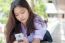 Portrait Of Thai High School Student Uniform Teen Beautiful Girl Using Her Phone And Smile