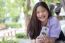 Portrait Of Thai High School Student Uniform Teen Beautiful Girl Using Her Phone And Smile