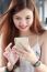 Portrait Of Thai Adult Beautiful Girl Using Her Smart Phone And Smile