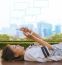 City Life Style Of Asian Woman Lying And Touching On Mobile Phone Screen Against Green Environment And Urban Skylind Background