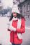 Beautiful Woman In Red Coat And Wool Cap And Gloves With Smartph