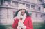 Beautiful Woman In Red Coat And Wool Cap And Gloves With Smartph