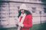 Beautiful Woman In Red Coat And Wool Cap And Gloves With Smartph