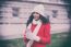 Beautiful Woman In Red Coat And Wool Cap And Gloves With Smartph