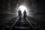 Couple Walking Together Through A Railway Tunnel