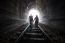 Couple Walking Together Through A Railway Tunnel