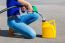 Woman Filling Yellow Can With Gasoline Or Petrol