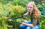 Young Dutch Woman Pruning Tree In Garden