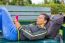 Dutch Woman Operating Mobile Phone Lying On Bench